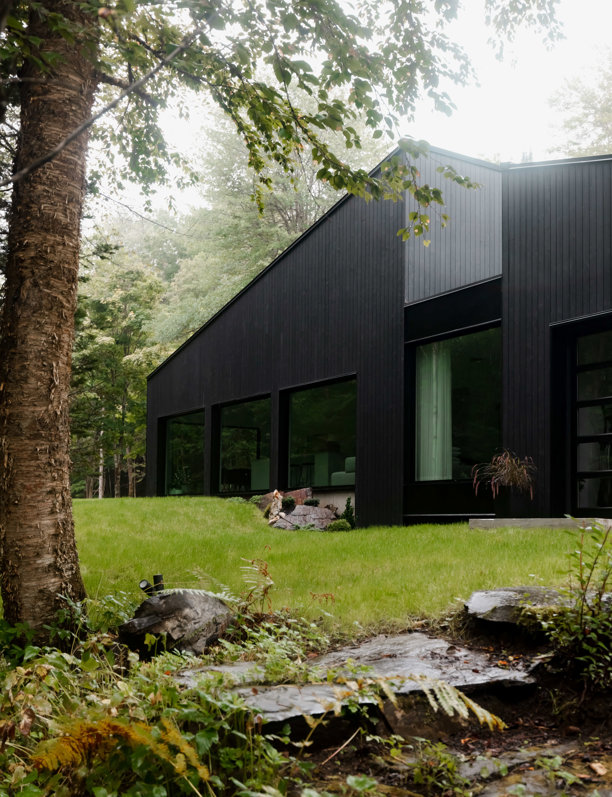 Una cabaña minimalista y deluxe en color negro que se integra en el paisaje