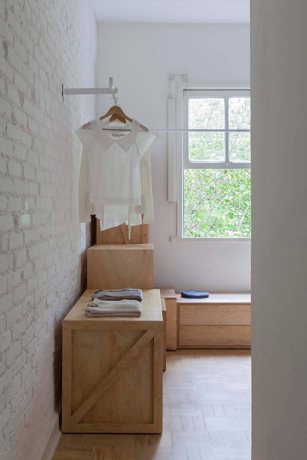 08-closet-1. En el vestidor se abre un gran ventanal cuadrado. La luz natural inunda esta casa aumentando la sensación de espacio que ya de por sí le dan sus paredes blancas