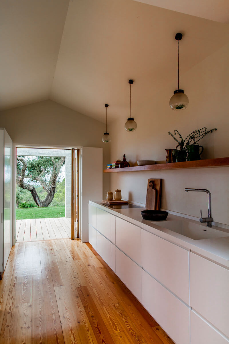 5b-. La cocina se compone de mobiliario lacada en blanco. La casa principal también dispone de una habitación doble y un cuarto de baño