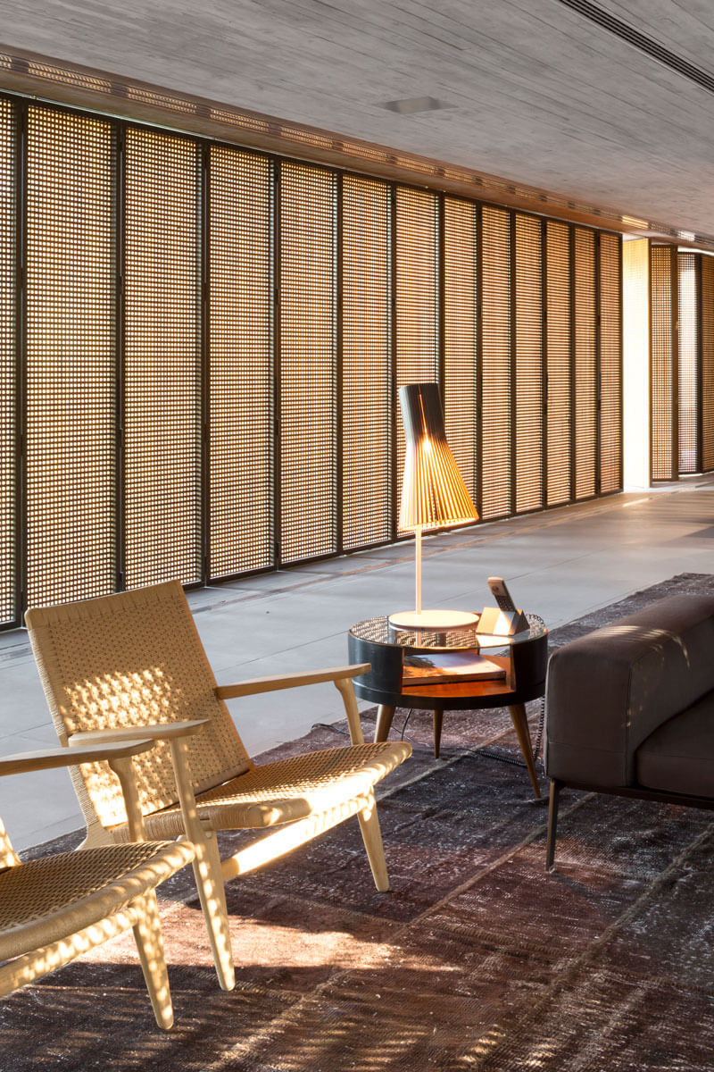 20. Las butacas son el modelo CH25 de Hans Wegner para Carl Hansen & Søn. La mesa lateral es un diseño redondo en madera y cristal del anticuario Thomaz Saavedra, mientras que la lámpara de mesa es de Secto Design