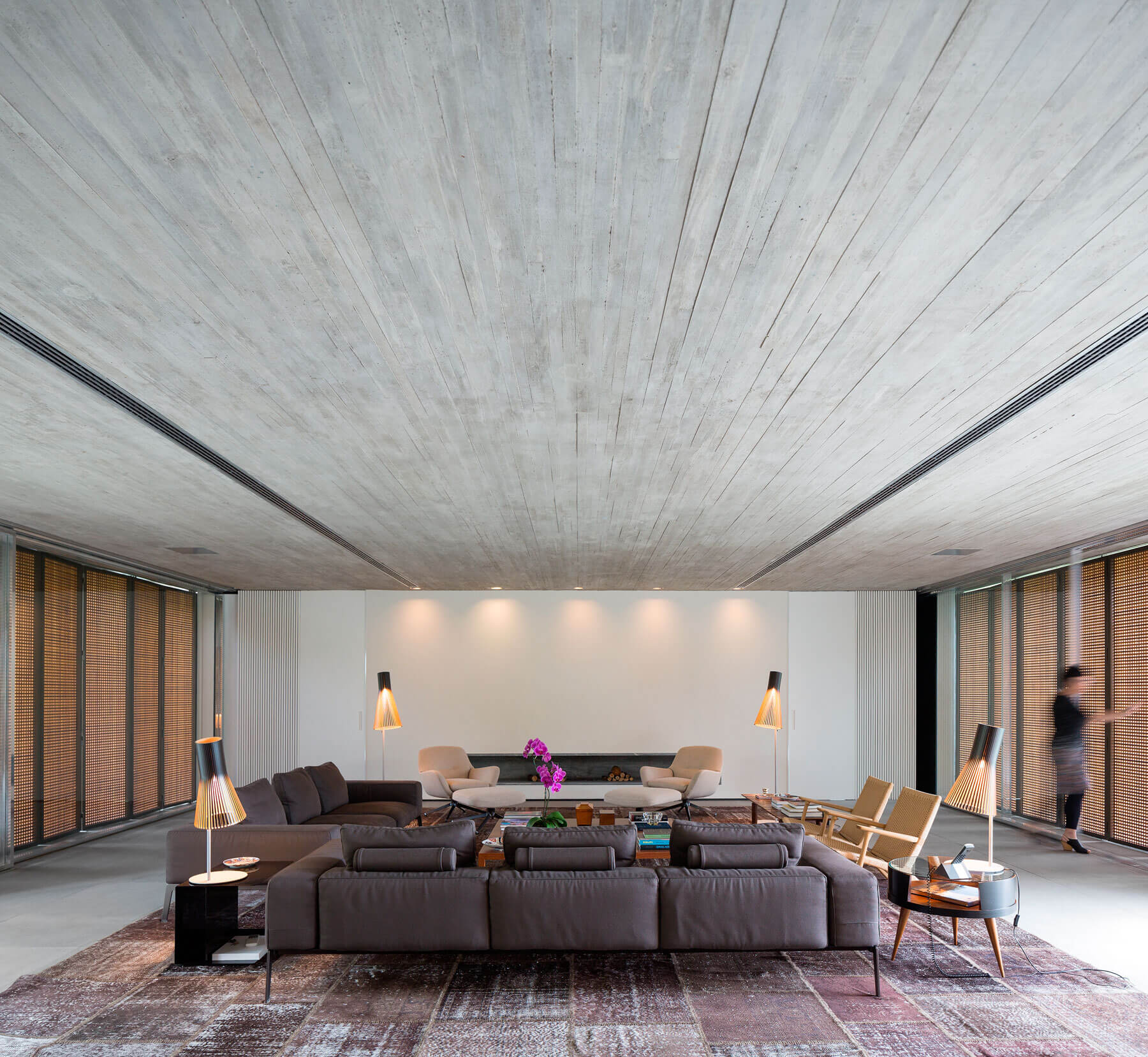 3. La casa se organiza alrededor de un espacio de día diáfano, que articula el resto de espacios de la vivienda. Los colores cálidos de los elementos textiles equilibran el carácter tectónico del hormigón
