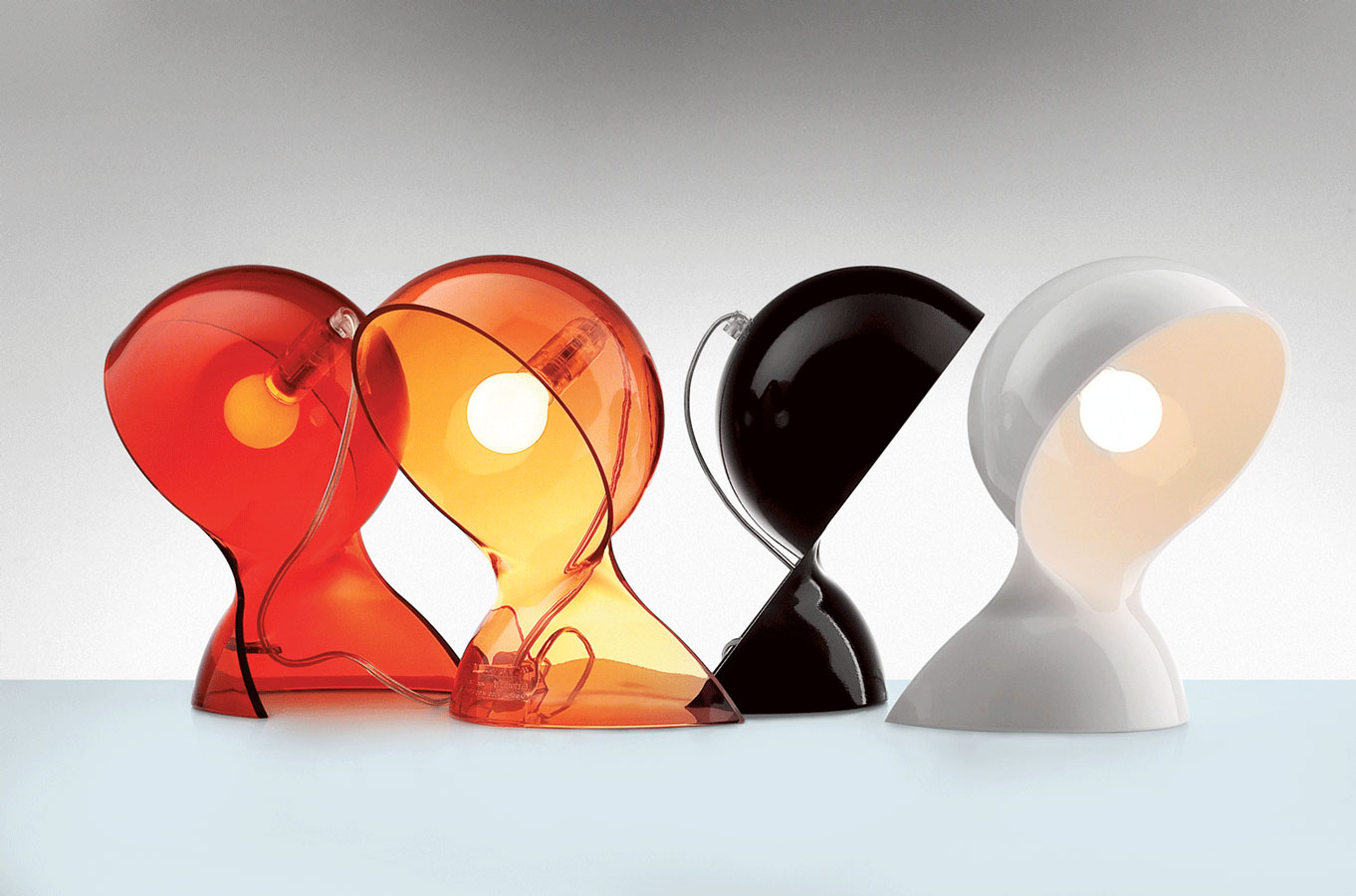 Cálidas . La versión transparente de las lámparas Dal de Artemide viene tintada en colores cálidos: naranja y rojo. Tienen un diseño ergonómico, de formas redondeadas, que encaja tanto en el dormitorio como en el recibidor, en el salón... Emiten una acogedora luz
