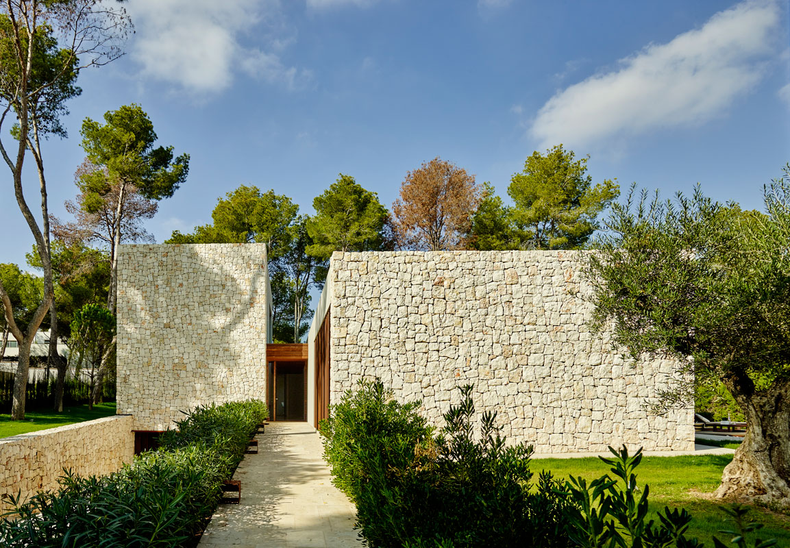 RamonEsteve8. Un bosque de pinos rodea esta casa, que ha extraído del paisaje que la rodea las referencias materiales con las que está construida, como la piedra caliza y los elementos de madera
