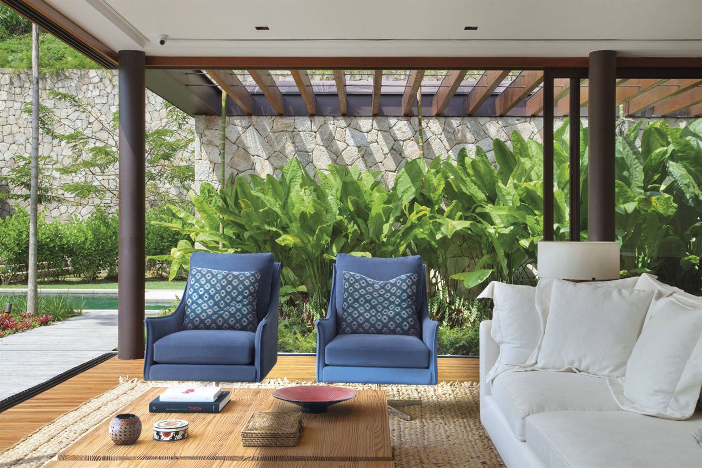 Jacobsen Arq1. Esta casa es un anexo de la vivienda principal, con un área reservada a los invitados, que incluye una acogedora sala de estar con cómodos sofás y sillones que da a la terraza