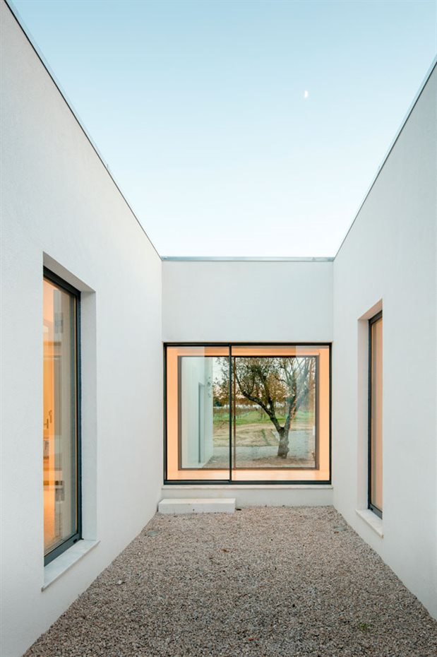 JM Casa Vinha 139. Un pequeño patio, alineado con otro de mayor tamaño, ofrece luz a los espacios situados al noroeste. El cruce visual entre ambos marca la transición a la zona más privada de la casa
