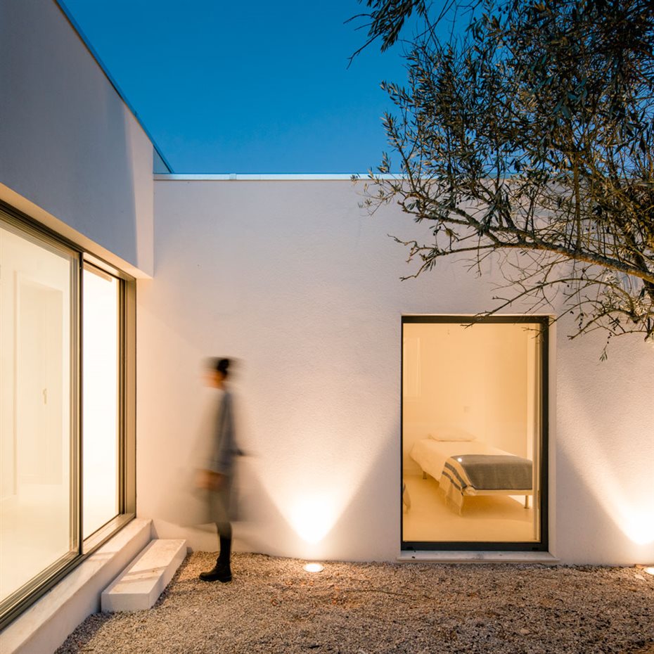 JM Casa Vinha 154. El patio principal ofrece múltiples puntos de conexión visual y demarca en ángulo la zona de los dormitorios y el corredor de acceso a la oficina, el salón y la cocina