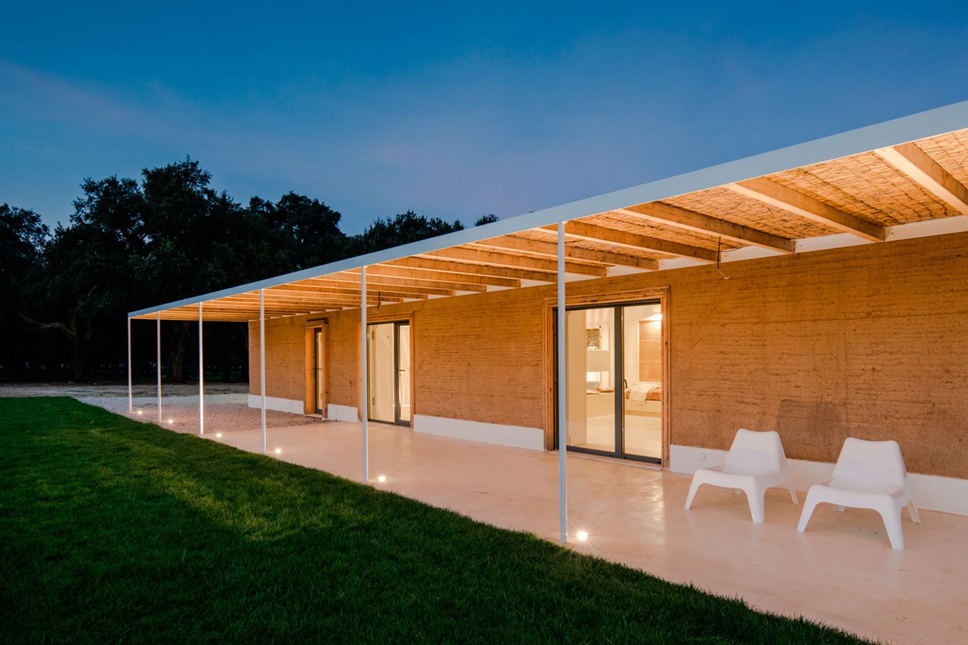 JM Casa Vinha 156. El patio principal ofrece múltiples puntos de conexión visual y demarca en ángulo la zona de los dormitorios y el corredor de acceso a la oficina, el salón y la cocina
