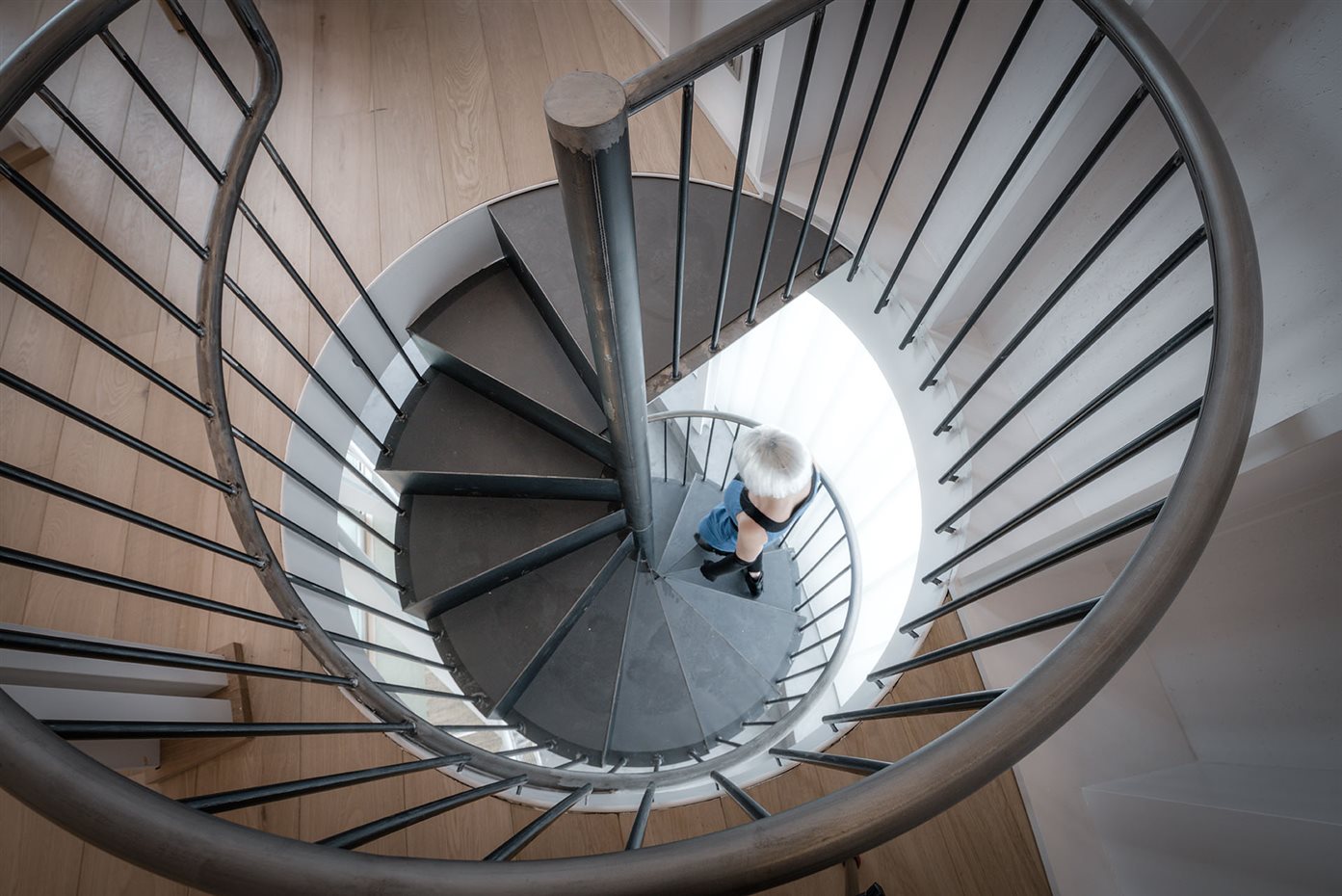 1605 z4z4 TB House 015. Una escalera de caracol conecta la planta superior con la entrada y el sótano, sirviendo asimismo de lucernario