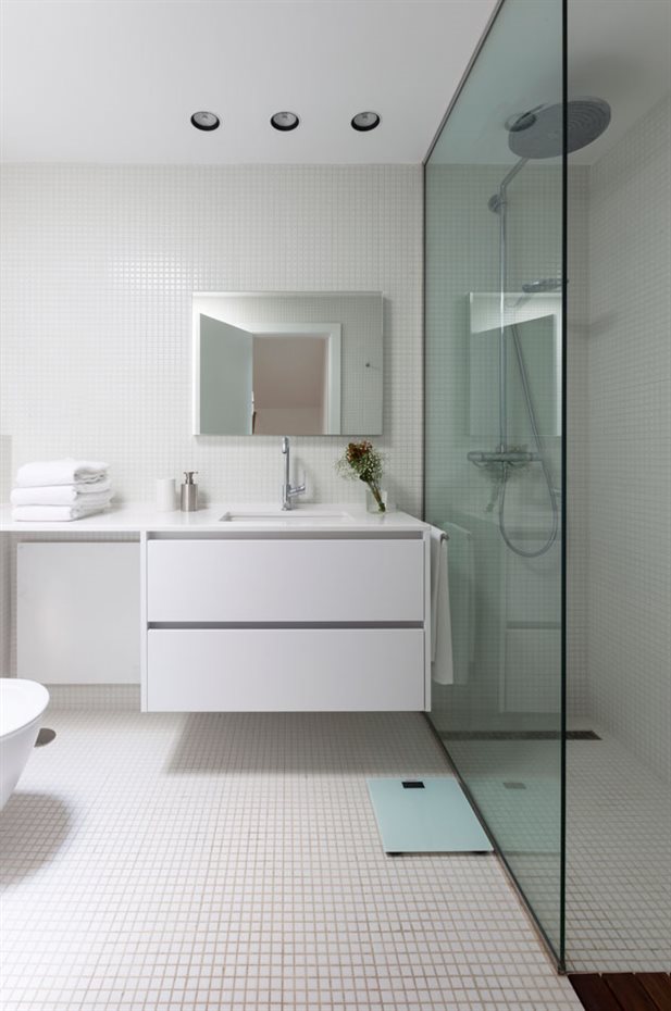 marbella34. El sentido práctico domina la planificación del baño. La ducha está separada mediante una única hoja de cristal fija. El lavabo se integra para facilitar su limpieza con un mueble suspendido bajo la encimera