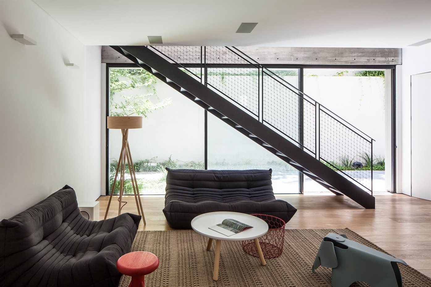 SHAIBEL HOUSE 049. En la planta baja se dispone otro pequeño estar. Sofás de Ligne Roset y elefante de madera diseño de los Eames fabricado por Vitra