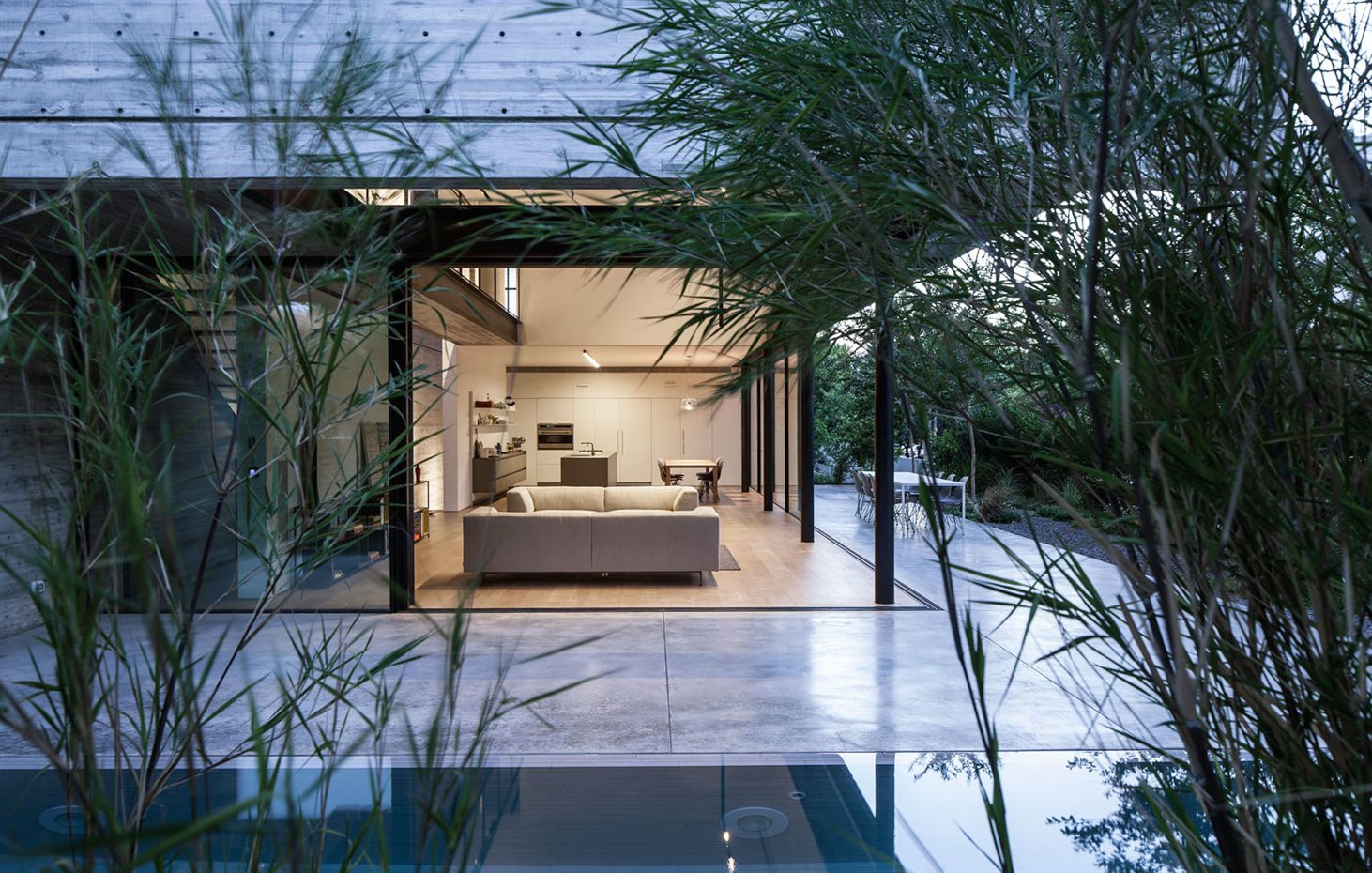SHAIBEL HOUSE 094. De noche, la fachada al jardín se cierra mediante grandes paneles correderos. El jardín protege la intimidad de la vida de la casa