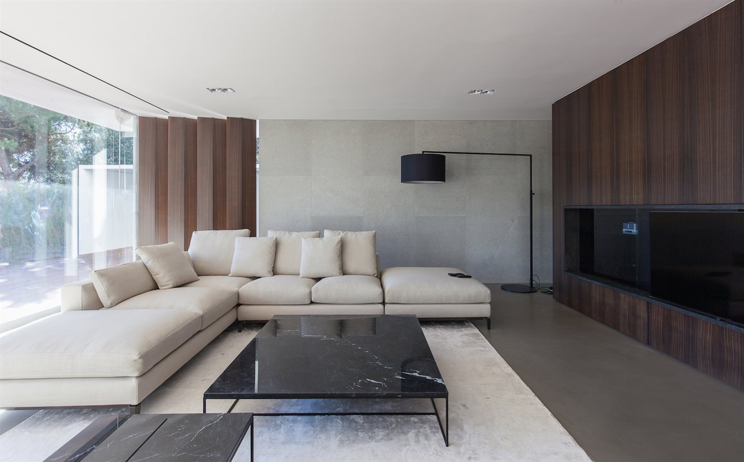 IMG 8972. La mesa de mármol negro Calder, de Minotti, descansa sobre una alfombra de sed beige claro de Elson&Company. La lámpara del fondo es el modelo High Noon de Zeitraum