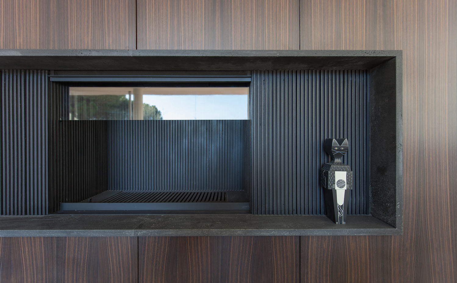 Un gran mueble hecho a medida integra una chimenea de acero, la televisión y un sistema de sonido