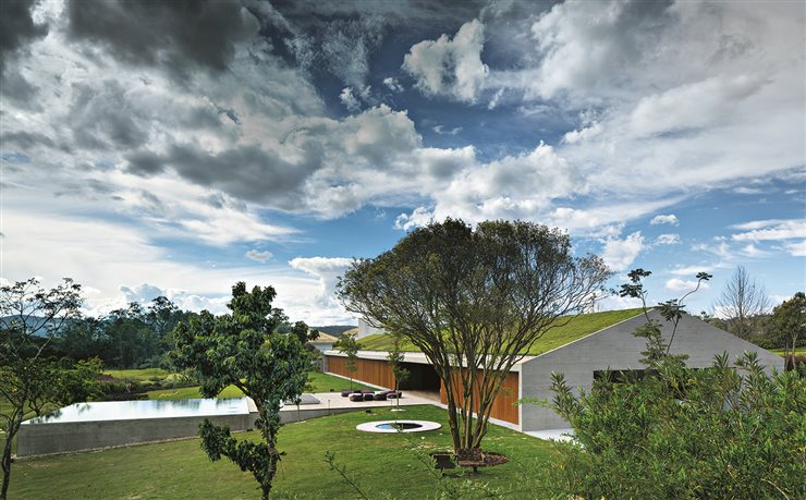 Con su cubierta verde inclinada, la casa MM en Bragança Paulista (Brasil), de Marcio Kogan, parece una suave ondulación del terreno
