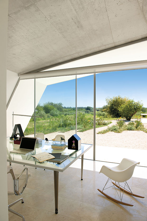 En torno a la mesa del estudio, diseño del arquitecto, las sillas Aluminium Group y RAR, de los Eames, editadas por Vitra