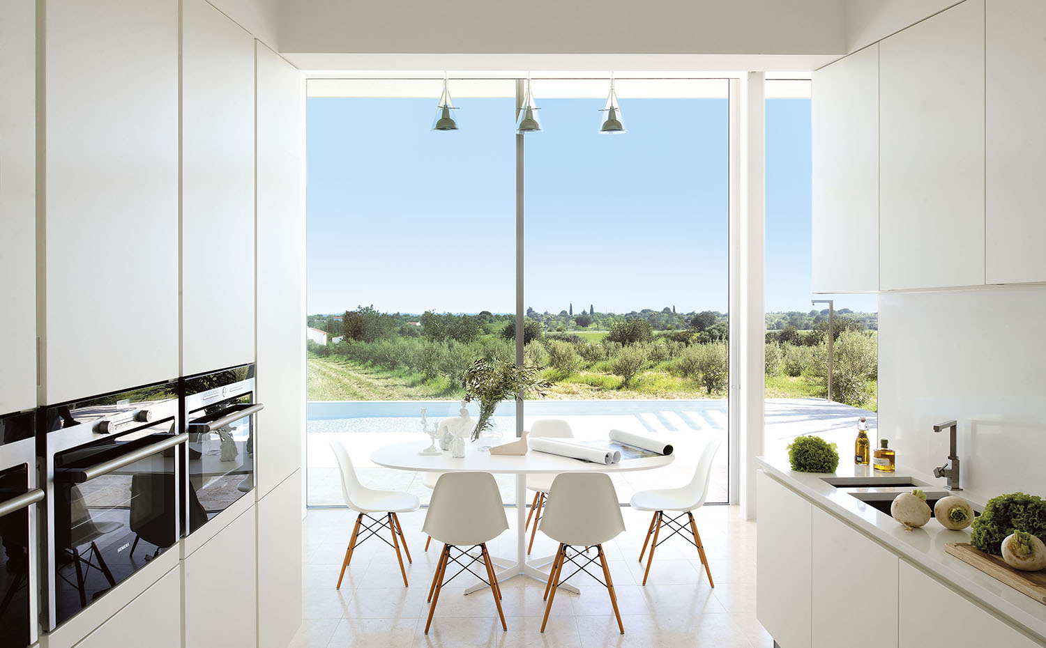 Mesa Eolo, de Lievore Altherr Molina para Arpe. Sillas DSW, de los Eames, editadas por Vitra