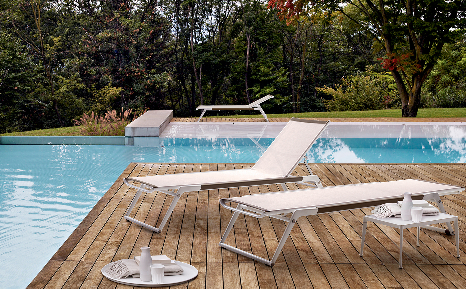 Mirto-Amb unite 2014. La terraza que rodea la piscina se ha pavimentado con tablones de madera dispuestos con junta abierta. Tumbonas Mirto, de Antonio Citterio