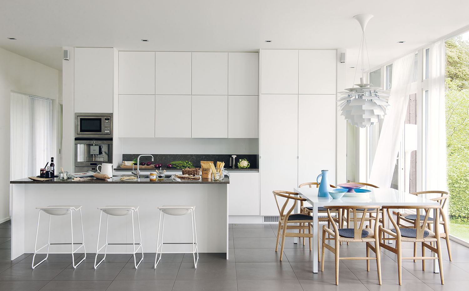00368267 ok. En el comedor, las sillas CH24, de Hans J. Wegner para Carl Hansen & Søn, y la lámpara PH Artichoke, de Poul Henningsen para Louis Poulsen