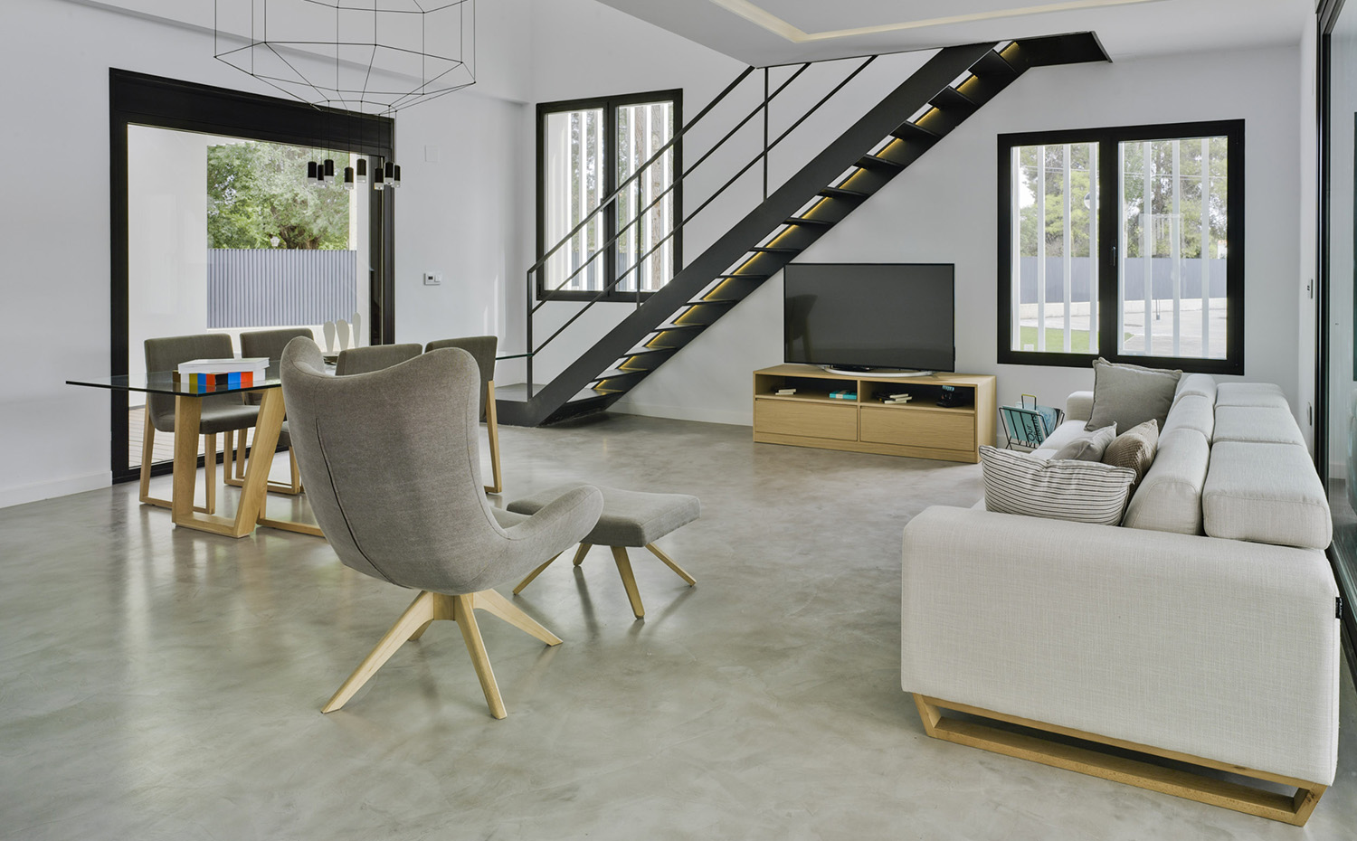 CASA F&A (13). Sofá Lime y butaca Lase, de Frajumar. Los suelos de las zonas públicas son de microcemento