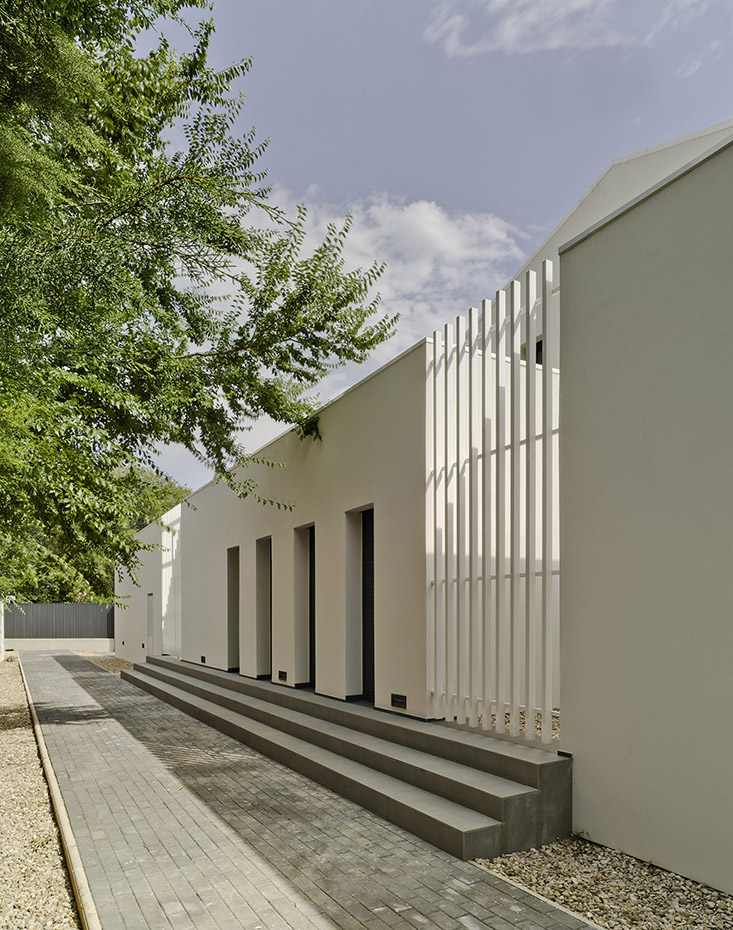 CASA F&A (6). La fachada orientada al extremo de la parcela, junto a la vía pública, ofrece un aspecto más hermético, con estrechas aberturas verticales