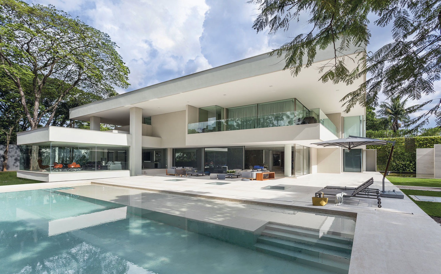 719-628-A01-385-120-j15. El jardín, la piscina, los profundos porches y las terrazas trazan el dibujo de los espacios exteriores. Las butacas del comedor, a la izquierda, son las Incisa, de Vico Magistretti para De Padova