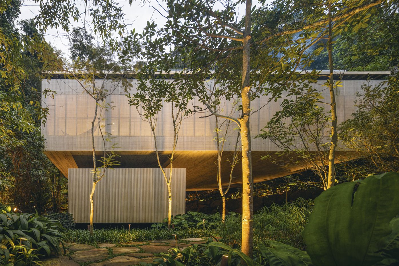 91. La casa se ha edificado sobre un terreno con una topografía accidentada y densa vegetación