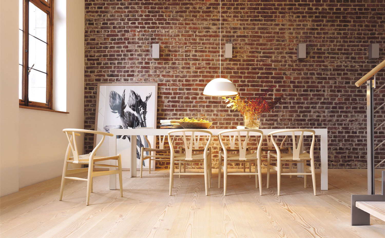 b1 011 4c U. El suelo de lama ancha de la marca Dinesen construye también las huellas de la escalera en este espacio en el que la madera está también presente en las sillas Y, diseño de Hans J. Wegner para Carl Hansen & Søn. Los marcos de la ventana son de madera envejecida.