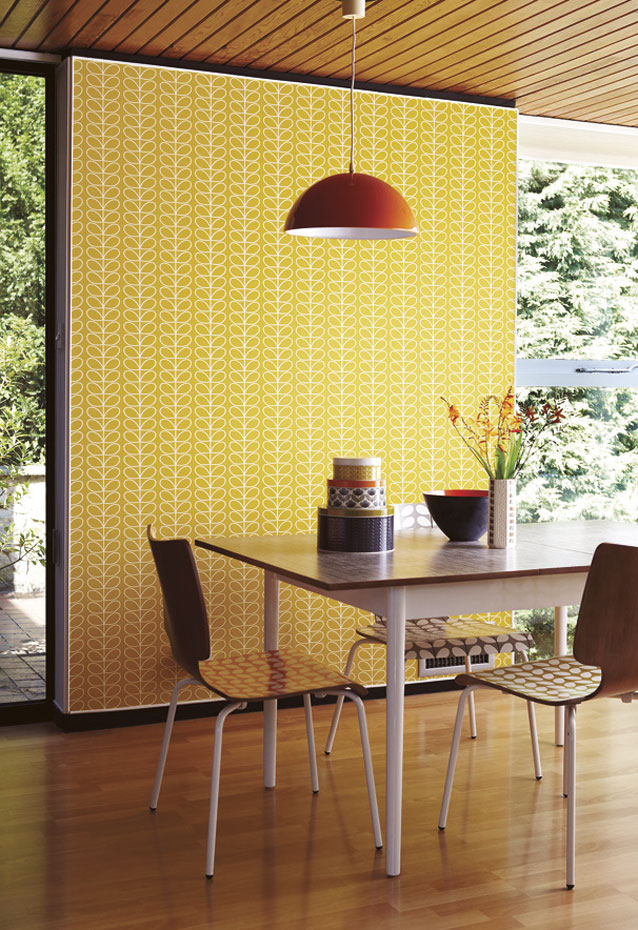 El papel pintado con motivos geométricos completa el look retro de este comedor pared