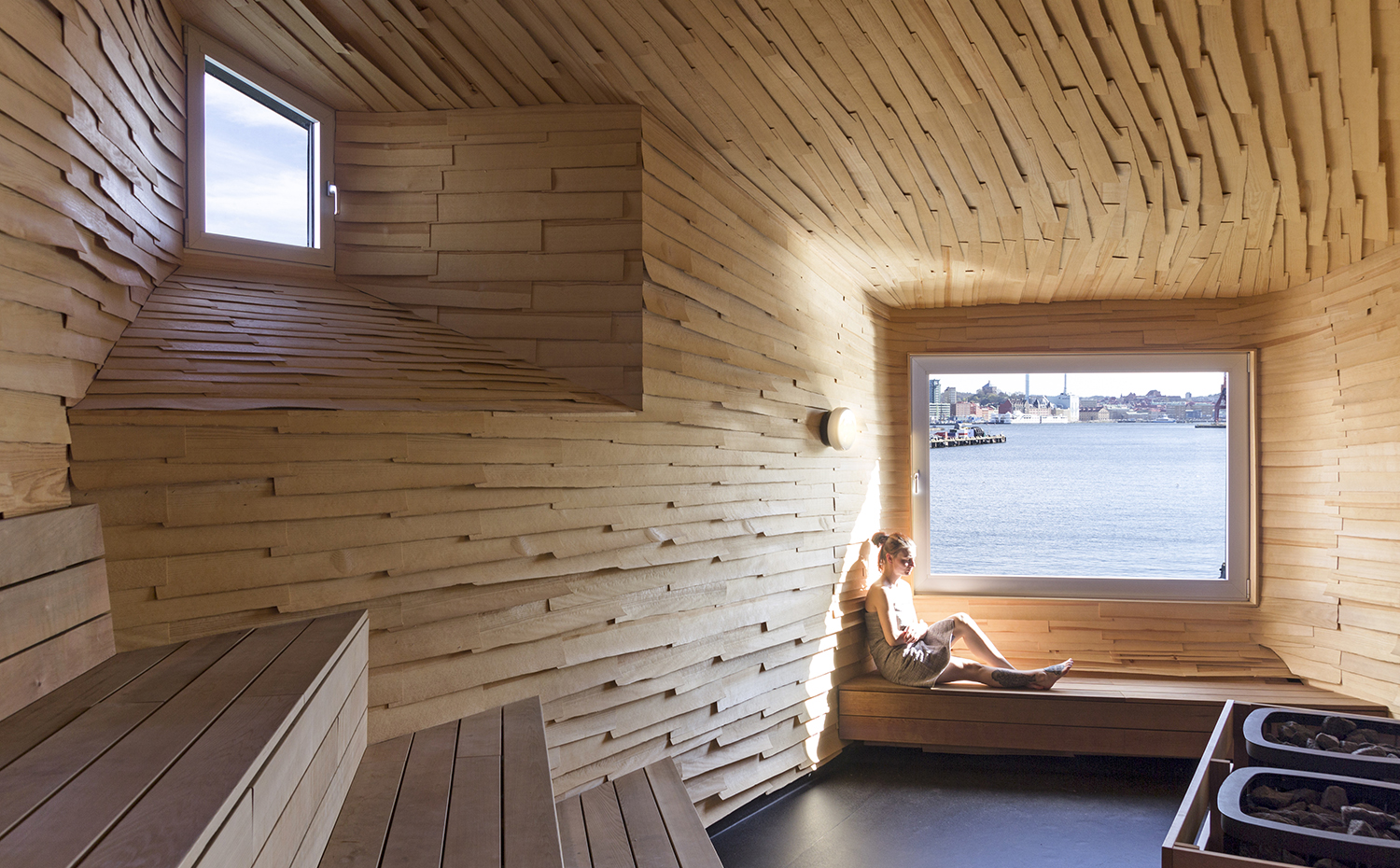 Raumlabor Göteborg sauna inside 2. La sauna de Gotemburgo, proyecto del estudio berlinés Raumlabor (2004), se encuentra en Frihamnen, el antiguo puerto industrial de la ciudad sueca. El interior está revestido con planchas de alerce dispuestas de modo irregular