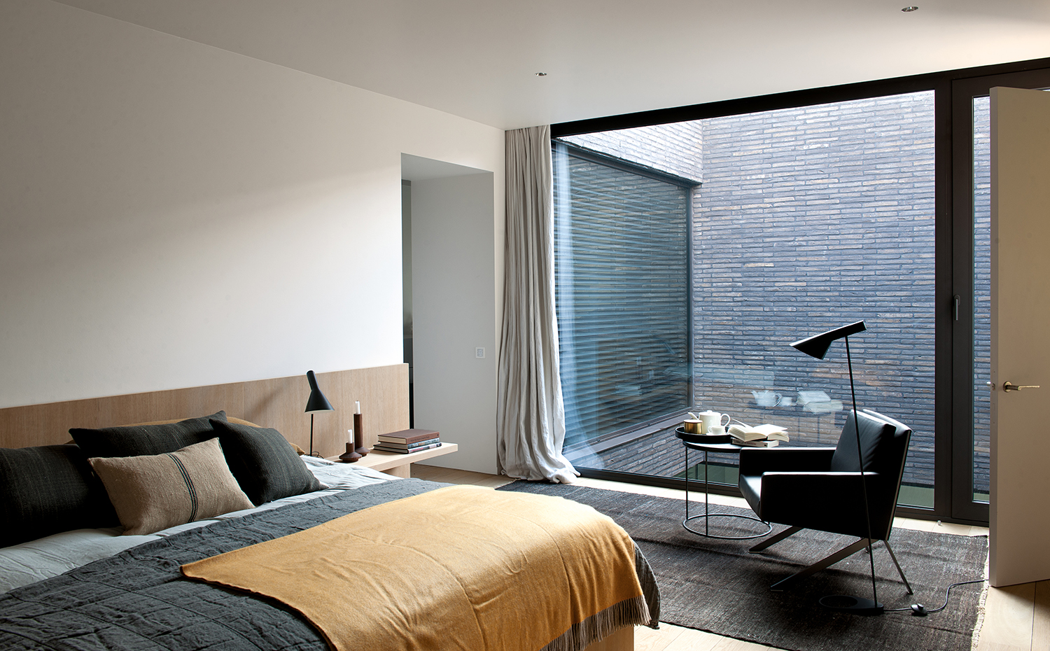 00377871 ok. Un patio interior ilumina con delicadeza el dormitorio. La cama y las mesillas de noche son un diseño del arquitecto. Ropa de cama, cojines y alfombra, de Huyghe Decoratie