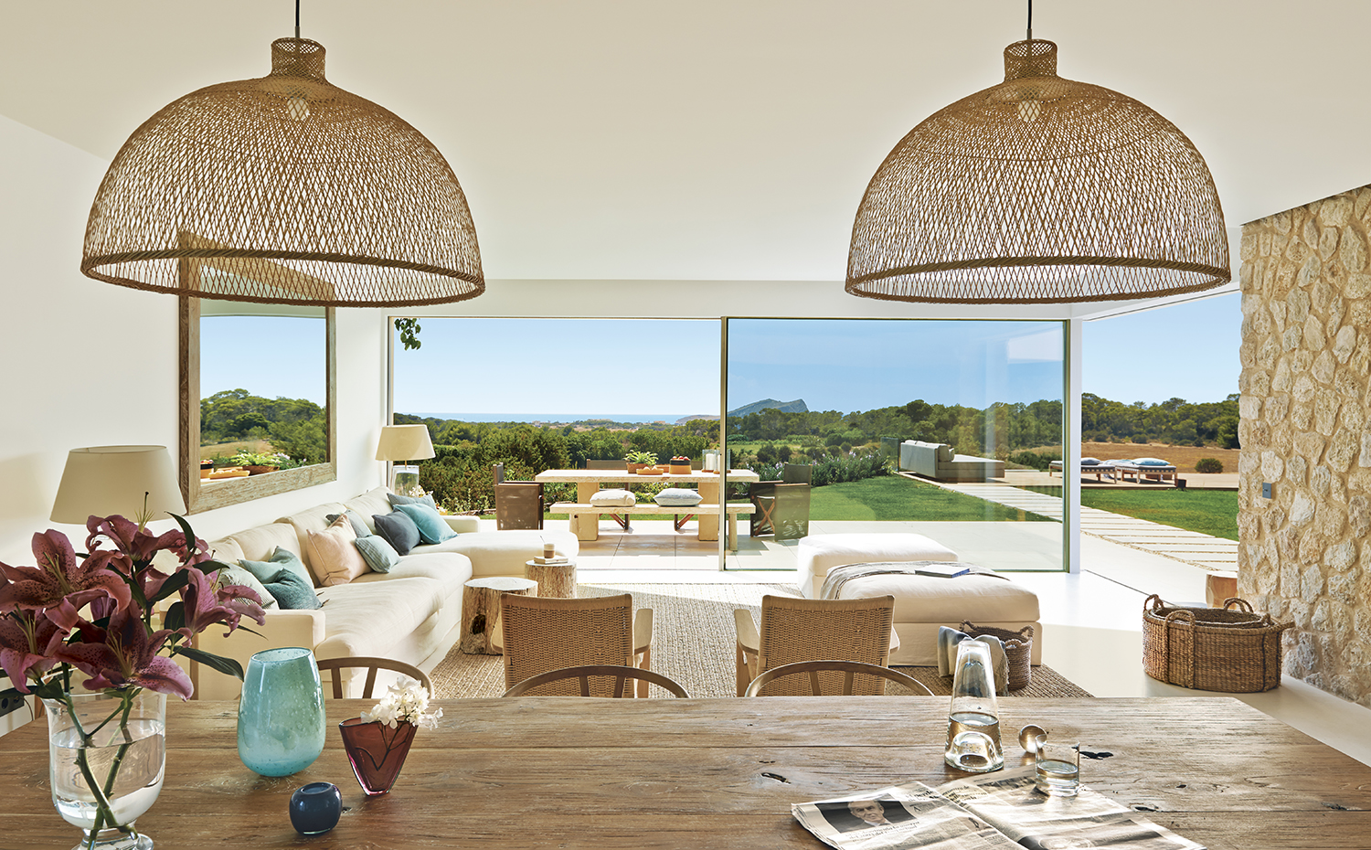 00387509 ok. En primer plano, el comedor, con una mesa procedente de Bali, adquirida en la tienda Ksar Living, Ibiza. Sillas CH24, de Hans J. Wegner para Carl Hansen & Søn. Lámparas Bamboo M1, de Ay Illuminate. Jarrones, en CoriumCasa