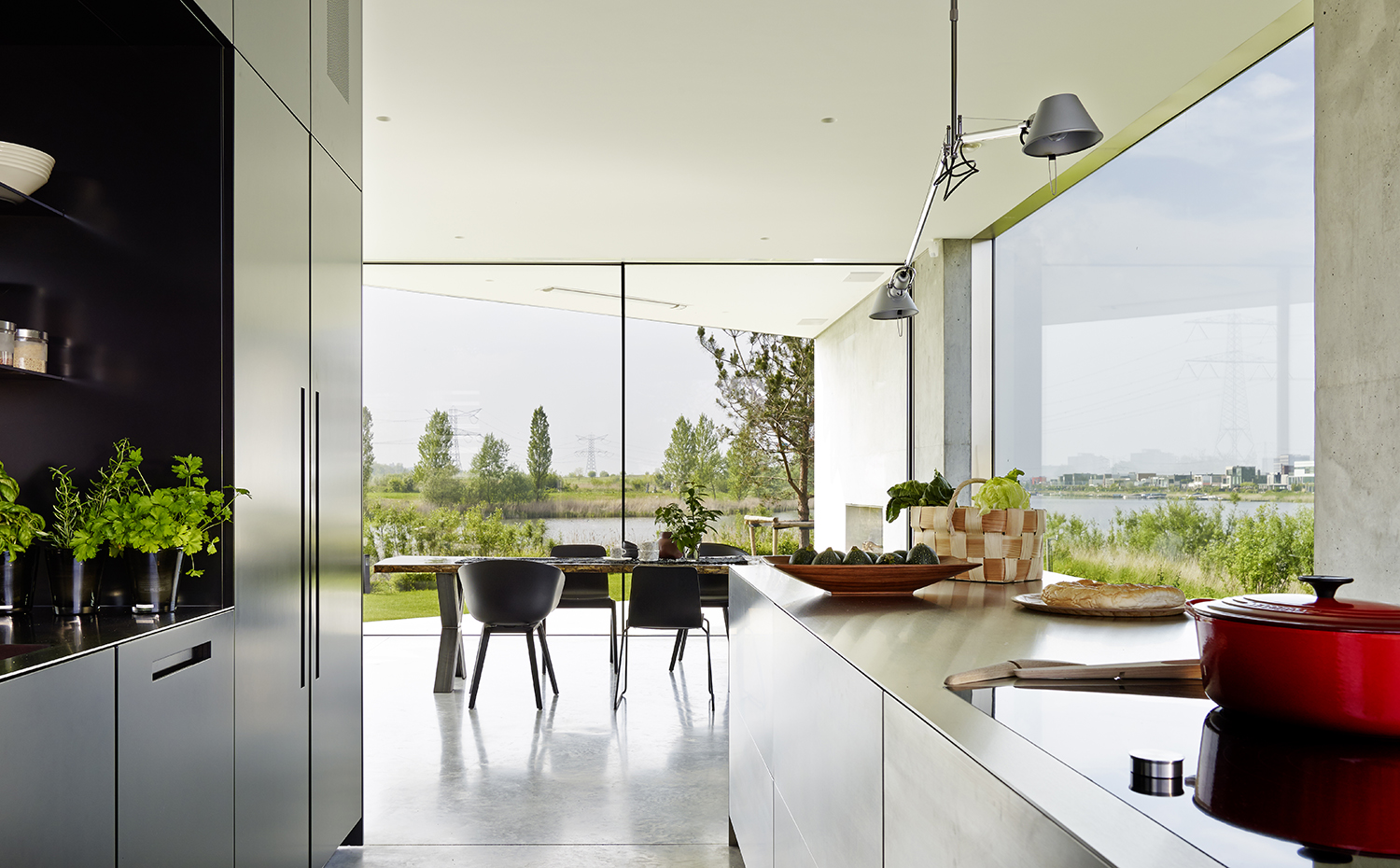 00387758 ok. Sobre la encimera de la cocina, la lámpara Tolomeo, de Michele de Lucchi y Giancarlo Fassina para Artemide. En el comedor, sillas de diferentes modelos del fabricante Hay