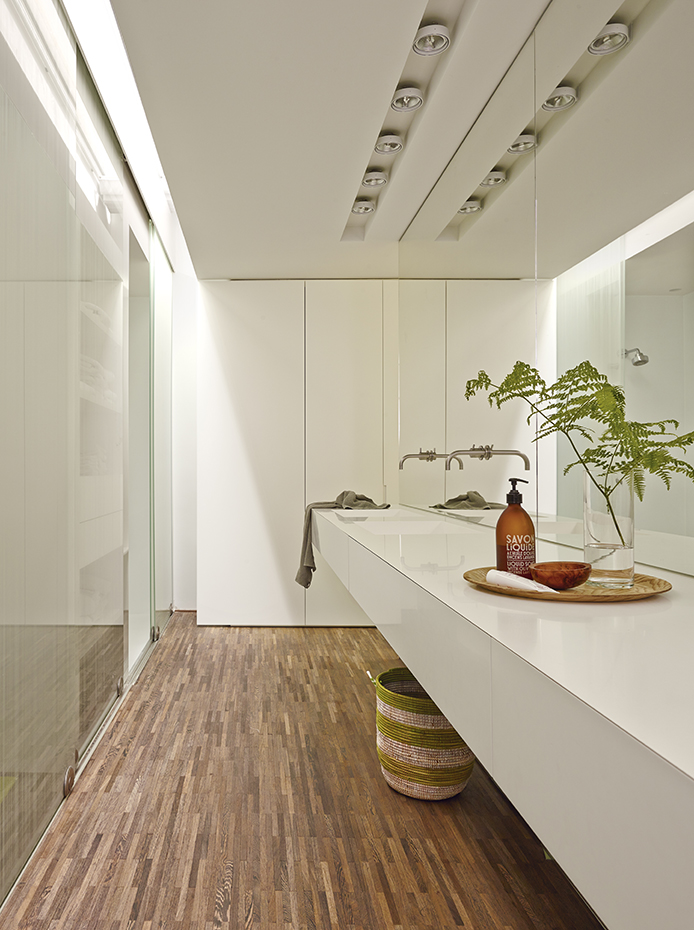 00388636 ok. Mobiliario de baño realizado a medida. El espejo tiene un sistema de calefacción que se activa automáticamente al encender la luz de la ducha. Grifería, de Vola, diseño de Arne Jacobsen. Bandeja de madera, de Habitat