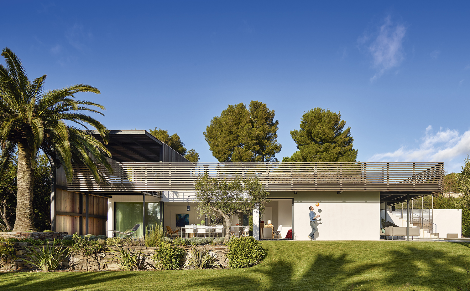 00398188 ok. Sobre la base de la construcción original, el arquitecto ha creado una estructura metálica revestida con lamas de madera que la recorre en todo su perímetro, generando terrazas elevadas y porches al abrigo del sol