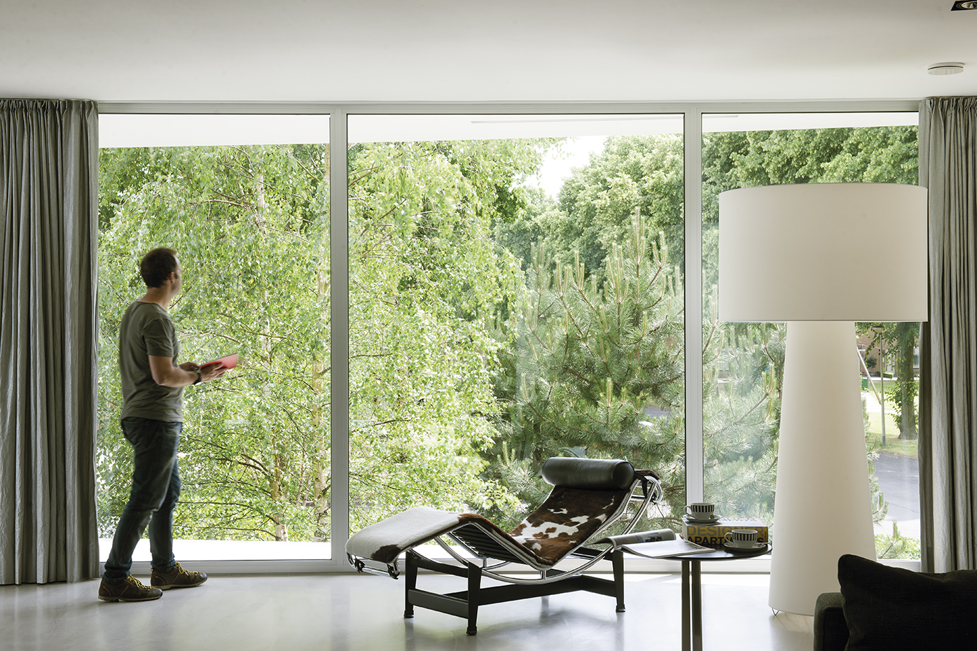 055 DSC1981-2. Frente al amplio ventanal del salón, la butaca LC4, de Le Corbusier, editada por Cassina. La lámpara es la Big Shadow, de Marcel Wanders para Cassina. El suelo de cemento continuo es de la firma DRT