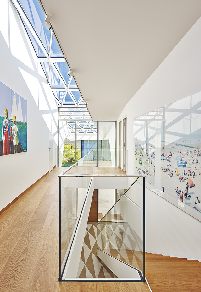 AyD-Carinthia A0134252. La estructura perforada de fibra de vidrio de la cubierta modula los efectos de luz y de sombra en los interiores. La fotografía de los bañistas es de Massimo Vitali. En la pared opuesta, una obra de Peter Kaimer