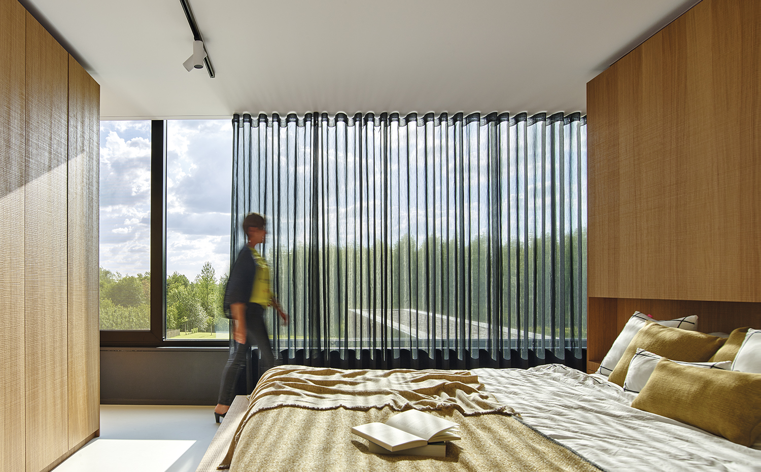 AyD-Meertens VG33827. La ligereza de la cortina permite tamizar la luz natural sin restar luminosidad al dormitorio. El cubrecama y el plaid son de la firma Teixidors