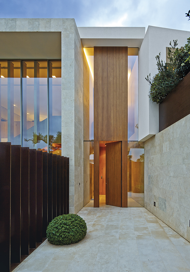 AyD-Negre (Mallorca)33004. El acceso adopta una forma rectangular en sentido vertical y a doble altura, formada por una tira de madera de roble flanqueada por franjas de cristal