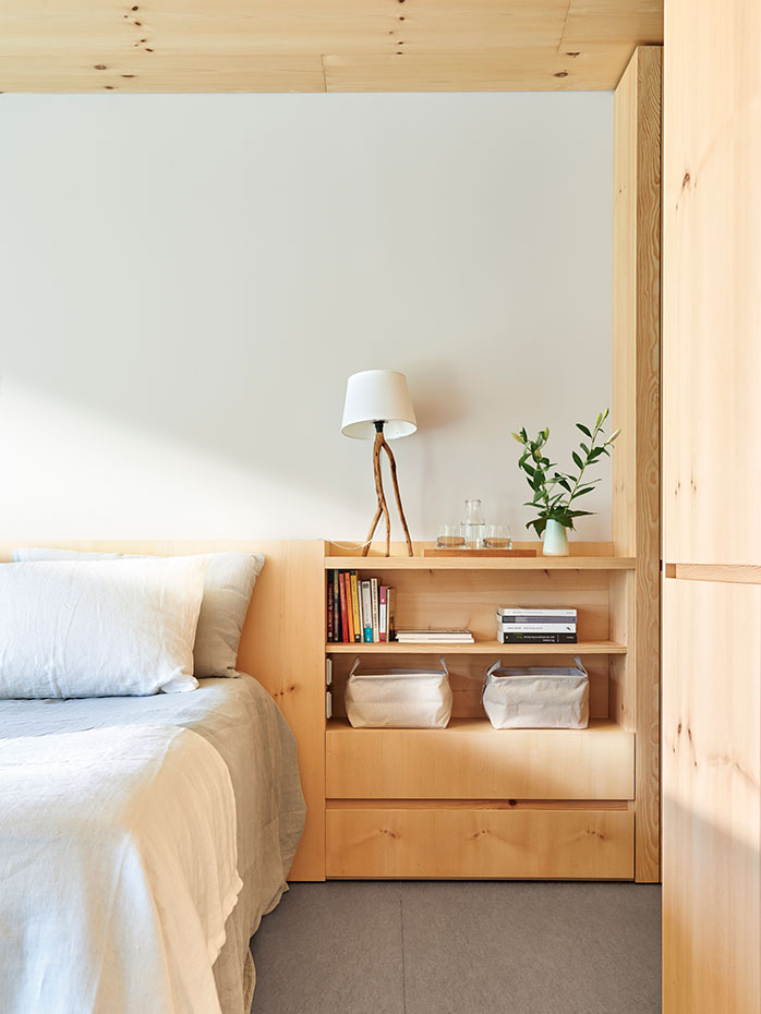 Cabecero de madera de pino, diseño de Coblonal arquitectura. Lámpara de sobremesa, modelo Lampal Vi, diseño de Kiko Tous para Brots