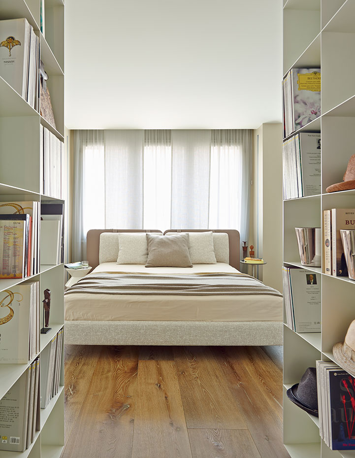 Piso reformado por el estudio Ferruz decoradors. Cama Tatlin-Soft de Rodolfo Dordoni para Minotti. Frente de armarios con estante para libros, de Minotti