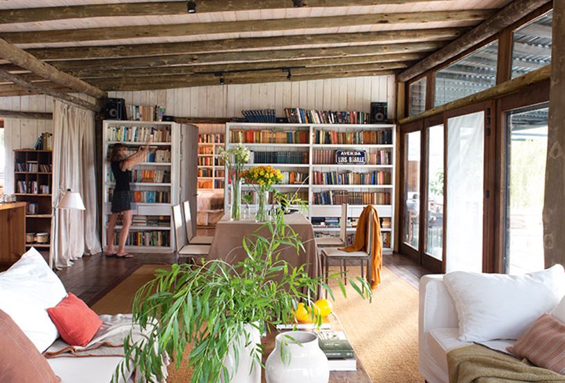 Una estantería con libros y una lámpara en la pared.