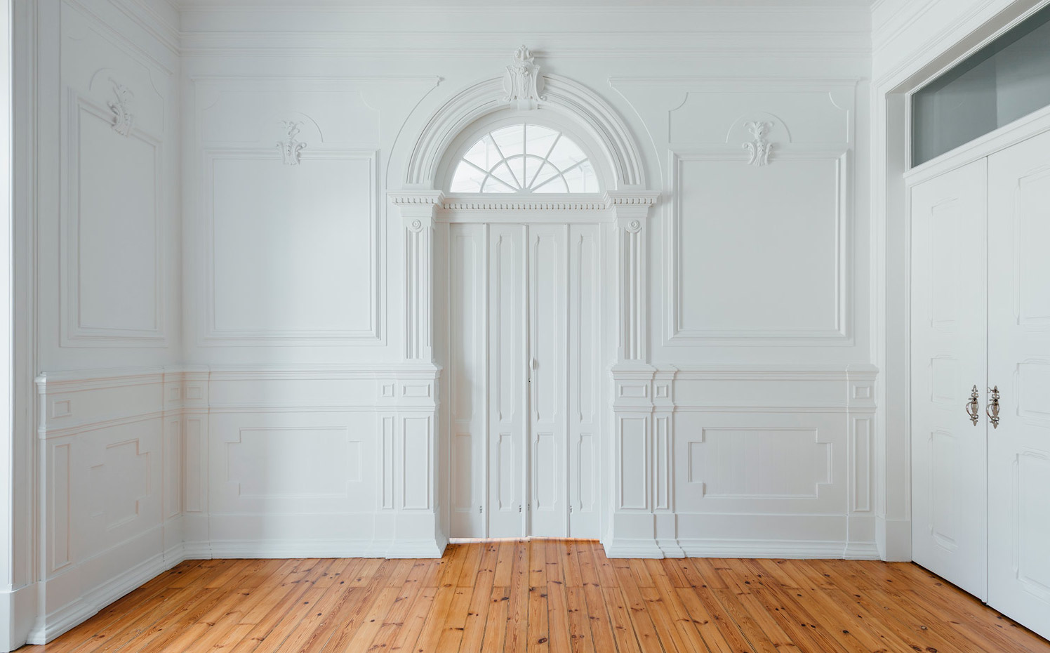 031. La puerta principal centenaria en blanco rodeada de las paredes artesonadas le da una enorme elegancia al espacio