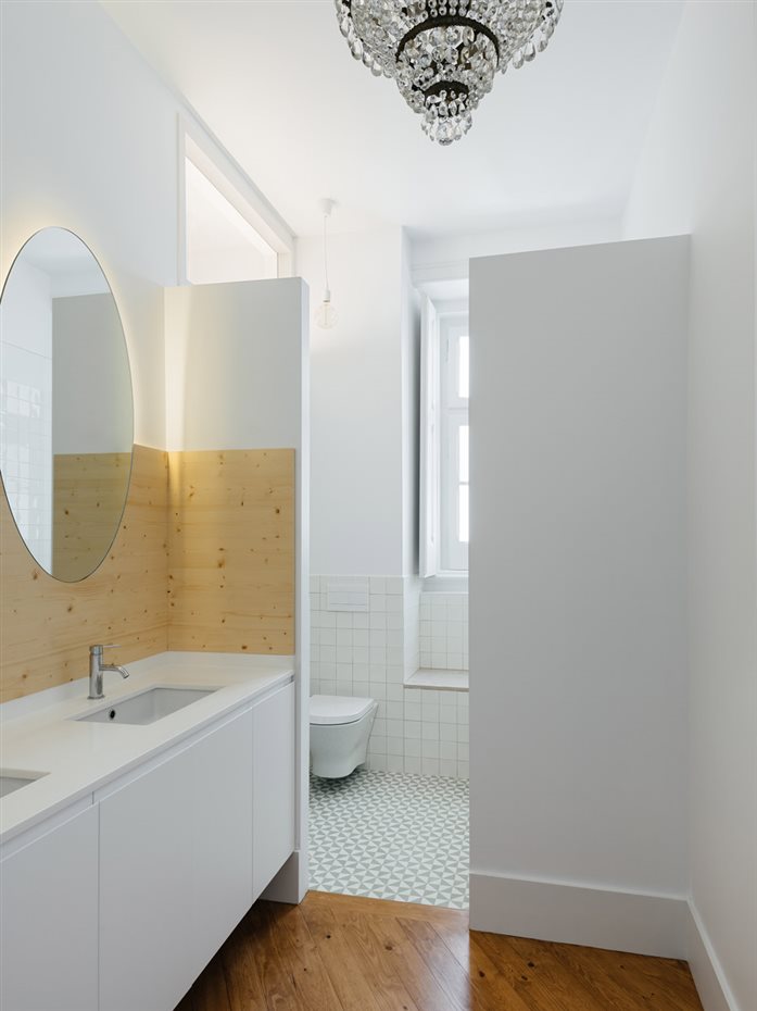 La lámpara de estilo clásico colgando del techo del baño es uno de los detalles que, dentro de la pulcritud, de la casa, consiguen darle viveza
