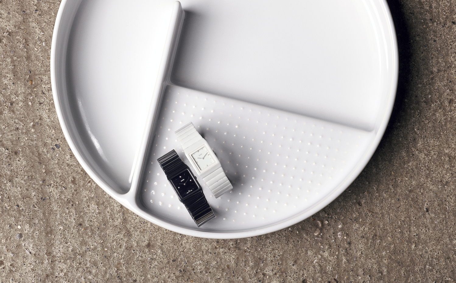 Blanco y negro. Sobre la bandeja de cerámica VAL (2015) para Laufen, también de Grcic, las versiones del reloj –en blanco y negro– con diamantes y dos agujas