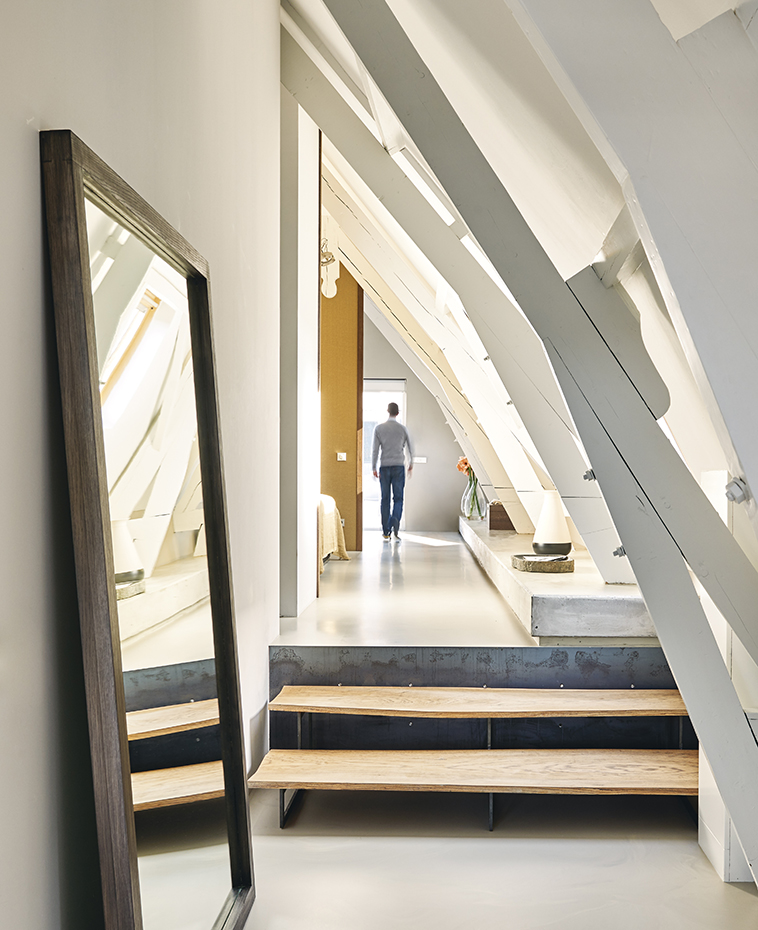 00407720 ok. Dos escalones de madera y acero azulado, diseñados por el arquitecto, conducen al dormitorio principal, situado bajo la cubierta