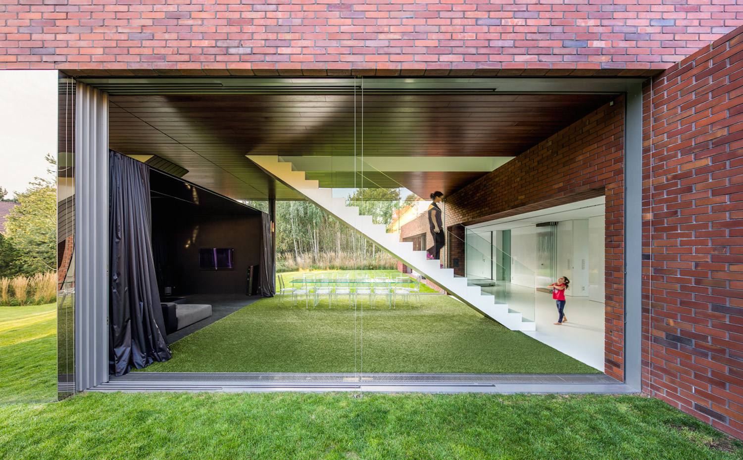 17 photo-Jakub-Certowicz Living-Garden-House-in-Katowice Robert-Konieczny-KWK-Promes. La escalera que conduce a la zona de noche desde el jardín luce imponente gracias a las paredes de cristal que le dan visibilidad extrema