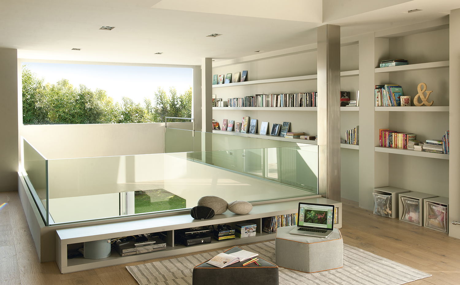 00396281 ok. Las tres plantas de la casa se comunican visualmente a través de dobles espacios y transparencias verticales. La biblioteca se desarrolla con estantes colocados en el perímetro del espacio y en torno al hueco central
