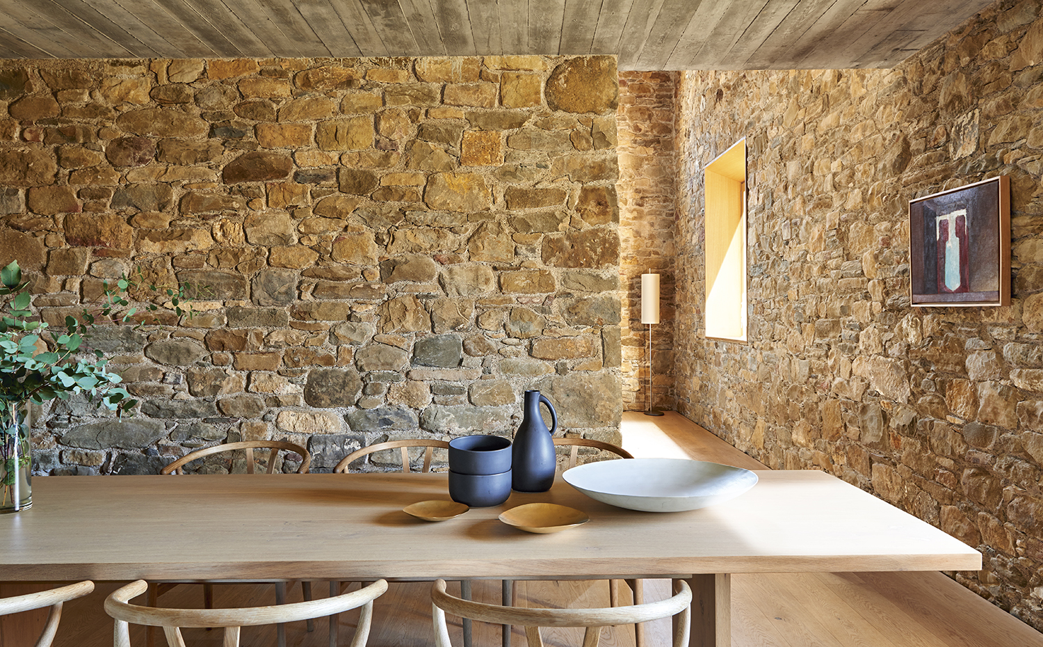 00398117 ok. Sobre la mesa de comedor, pieza de cerámica blanca de Rina Menardi y cerámicas negras de Ay Illuminati. Junto a la ventana, la lámpara AJ Royal, de Arne Jacobsen para Santa & Cole