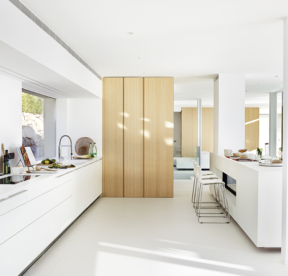 00401218 ok. El mobiliario integral es el sistema b3, de bulthaup, con acabado lacado en blanco. La encimera, con fregadero integrado, es el modelo Krion Solid Surface, de Porcelanosa. Taburetes Glenn, de Ikea. La placa de inducción es de Neff