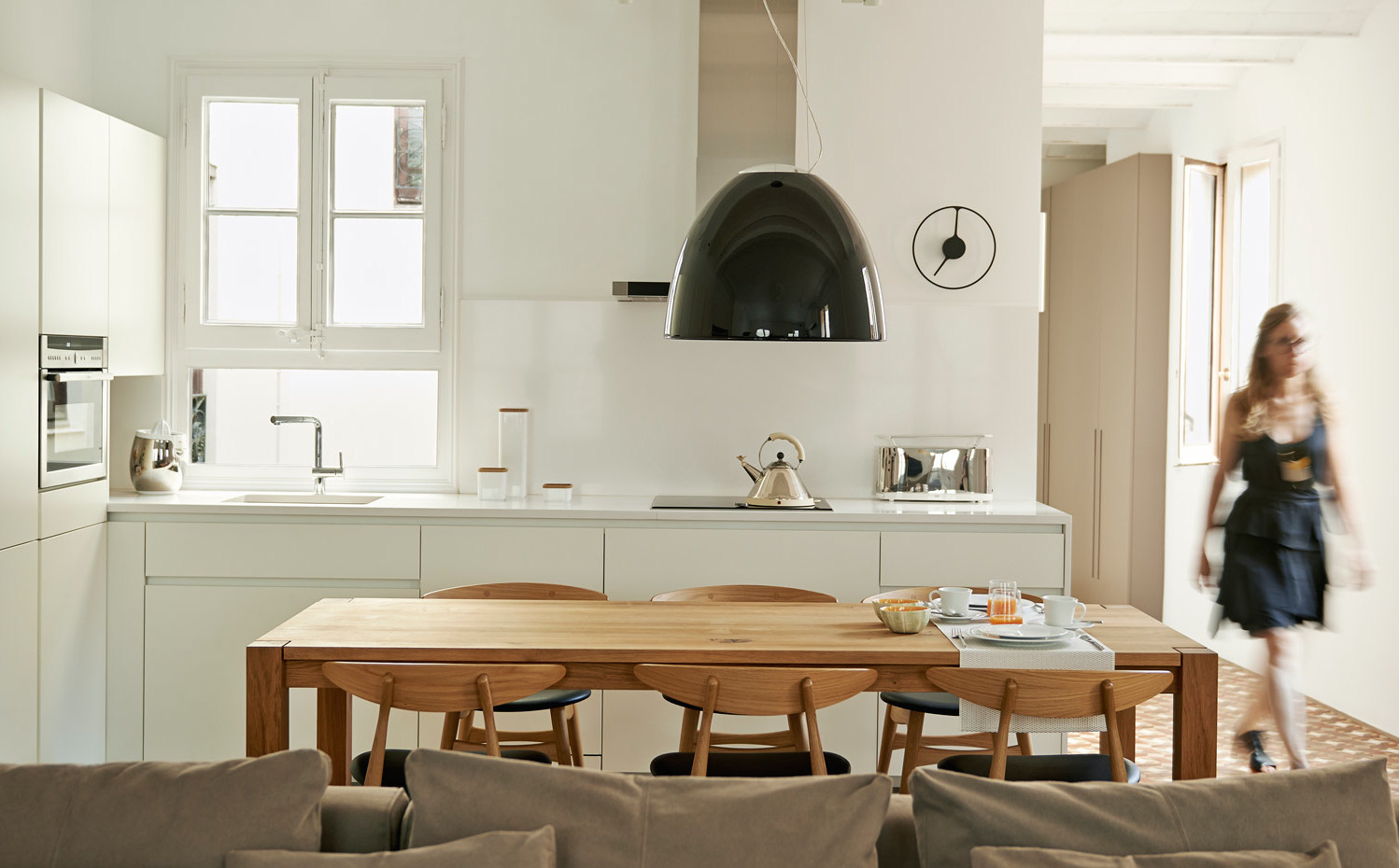 estudio-vilablanch-reforma-piso-Gótico-3. La cocina se dejó en el lugar original pero se agrandó y se tiraron tabiques, de modo que ahora queda abierta al salón comedor. La mesa es la Madame Lillie de E15 y las sillas son las CH33 de Carl Hansen